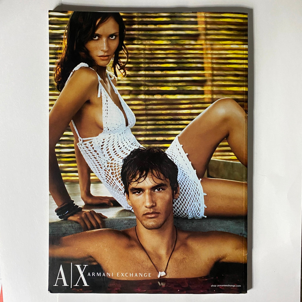 Cover of A|X Armani Exchange magazine showcasing a model in a white crochet dress alongside a male model, representing contemporary fashion styles.