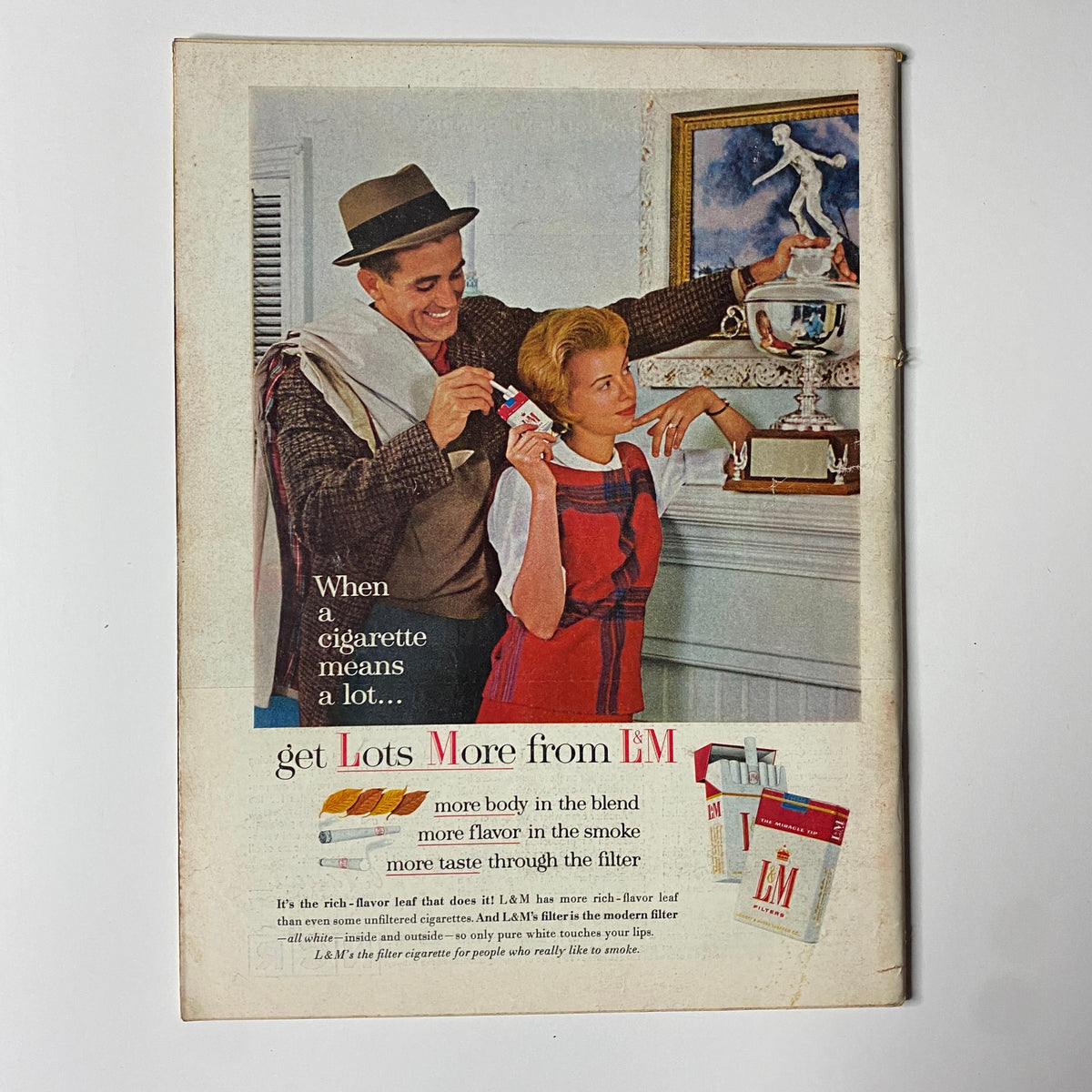 Vintage L&M cigarette advertisement featuring a man and woman promoting the brand, with the text discussing the quality of the cigarettes.
