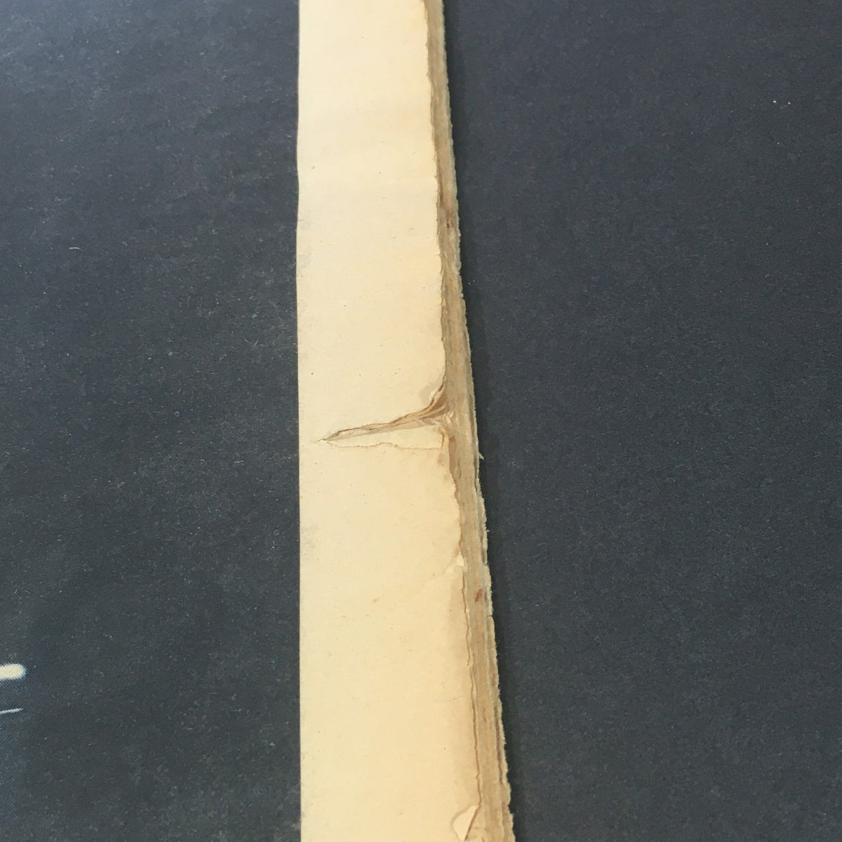 Close-up of a damaged edge of VTG Rolling Stone Magazine June 16 1977, illustrating the magazine's vintage condition and character.