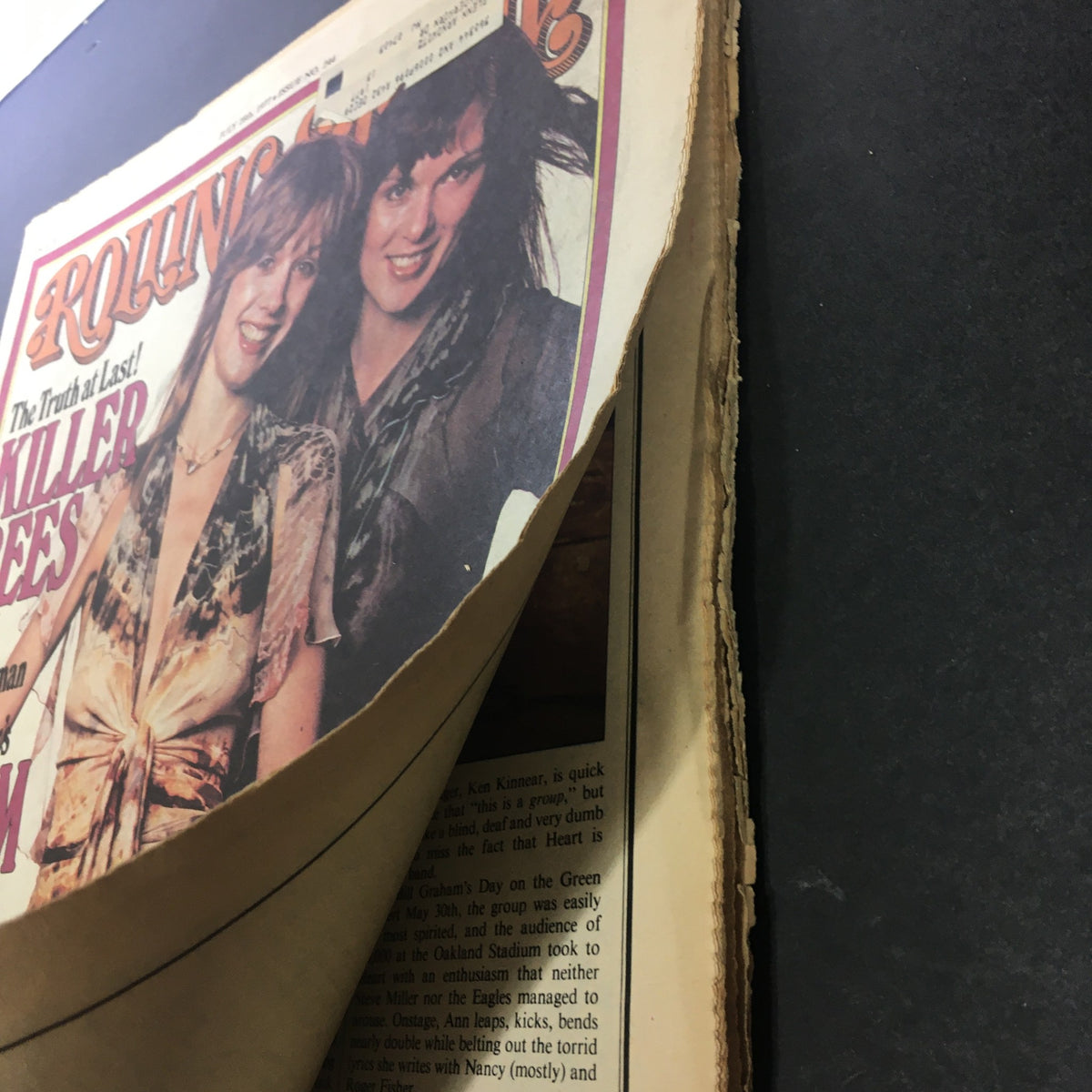 Vintage Rolling Stone Magazine from July 28, 1977 featuring Nancy Wilson and Ann Wilson on the cover, displaying visible wear and a partially opened page, ideal for rock music collectors.