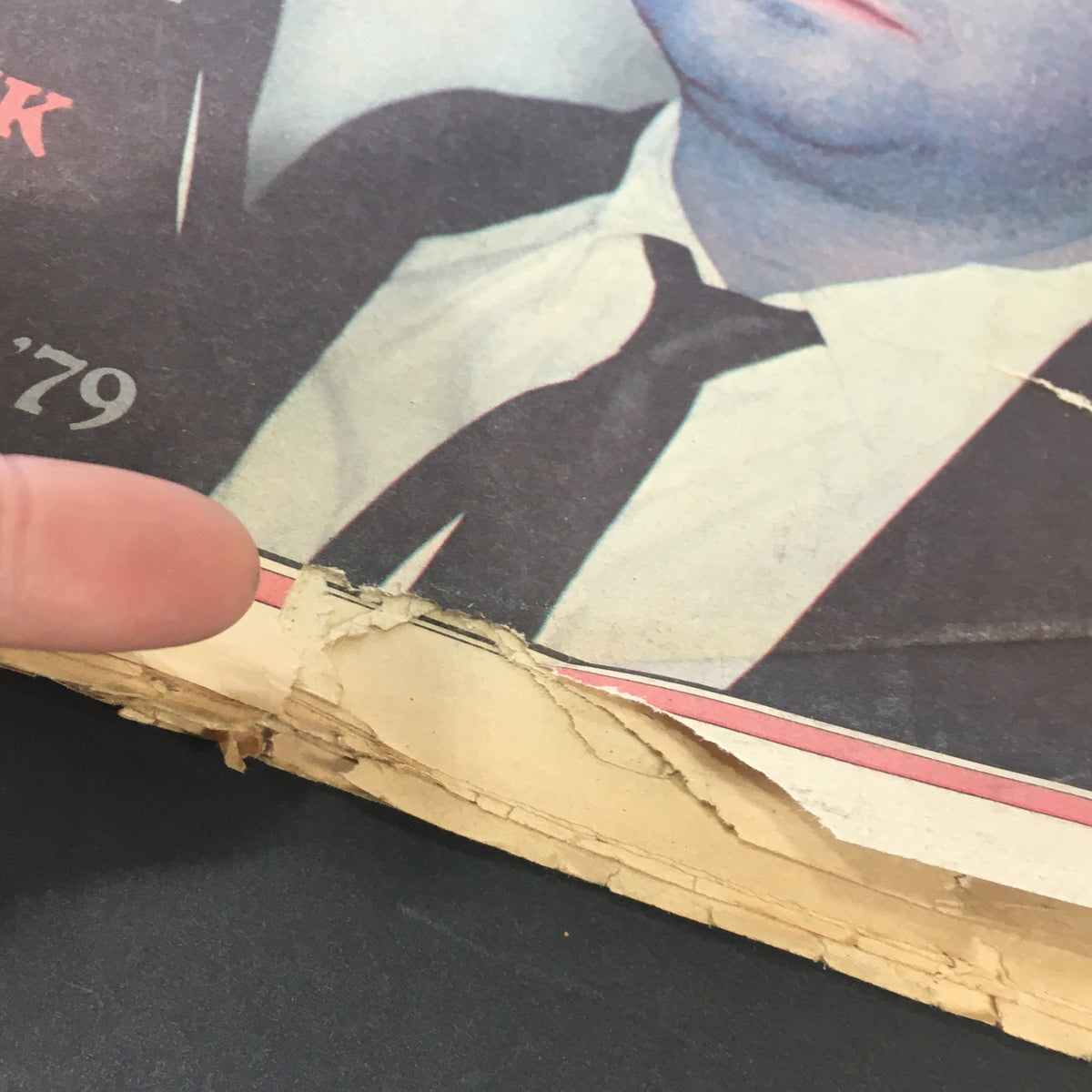 Close-up of the edge of the Vintage Rolling Stone magazine from February 22, 1979, featuring visible wear and tear, showcasing the historical significance of the Blues Brothers issue with Dan Aykroyd.