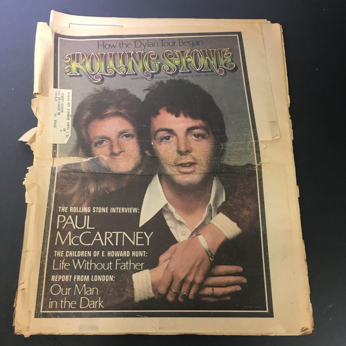 Vintage Rolling Stone Magazine cover from January 31, 1974, featuring Paul McCartney and an unidentified individual, highlighting the start of the Dylan tour. The magazine showcases wear with visible rips and an address label.