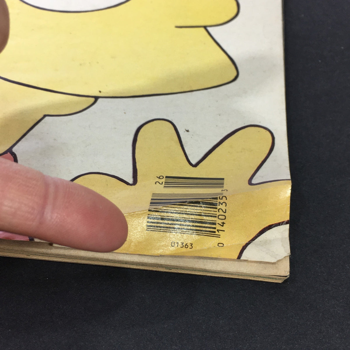 Close-up image of a vintage Rolling Stone magazine from June 28, 1990, featuring Bart Simpson and P.J. O'Rourke, highlighting a barcode and finger pointing at it.