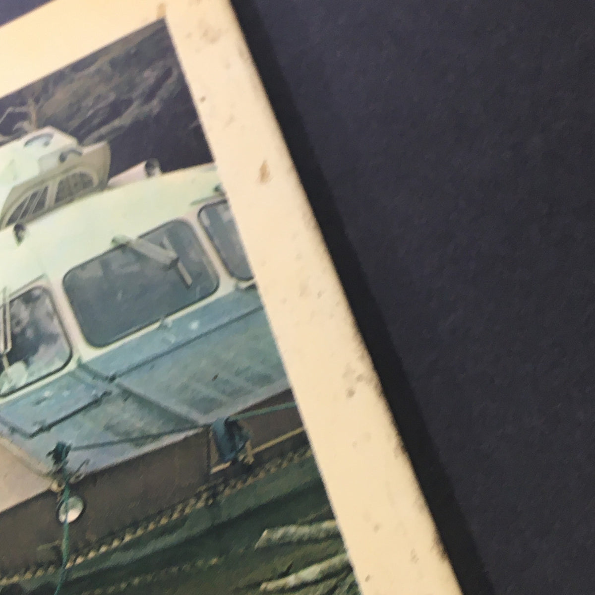 Close-up view of the back cover of Geographical magazine, focusing on a classic boat parked by the shore, indicating an exploration of geography in a picturesque setting.