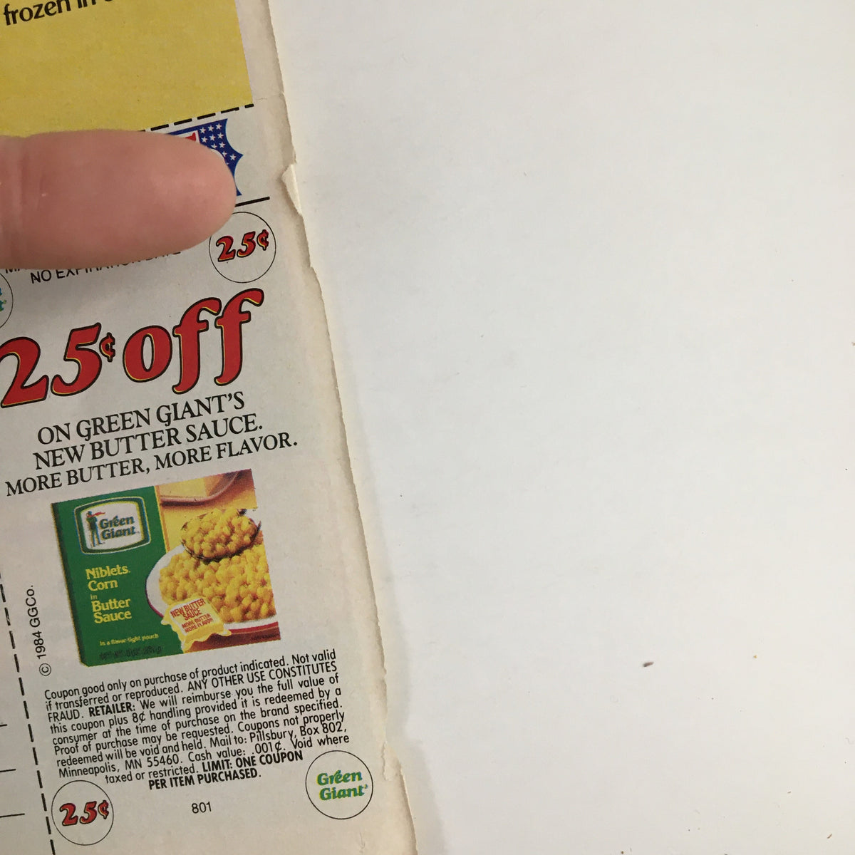 Close-up of a vintage coupon from the 1984 Green Giant Niblets Corn advertisement, showing a $0.25 discount offer on Green Giant's new butter sauce product.