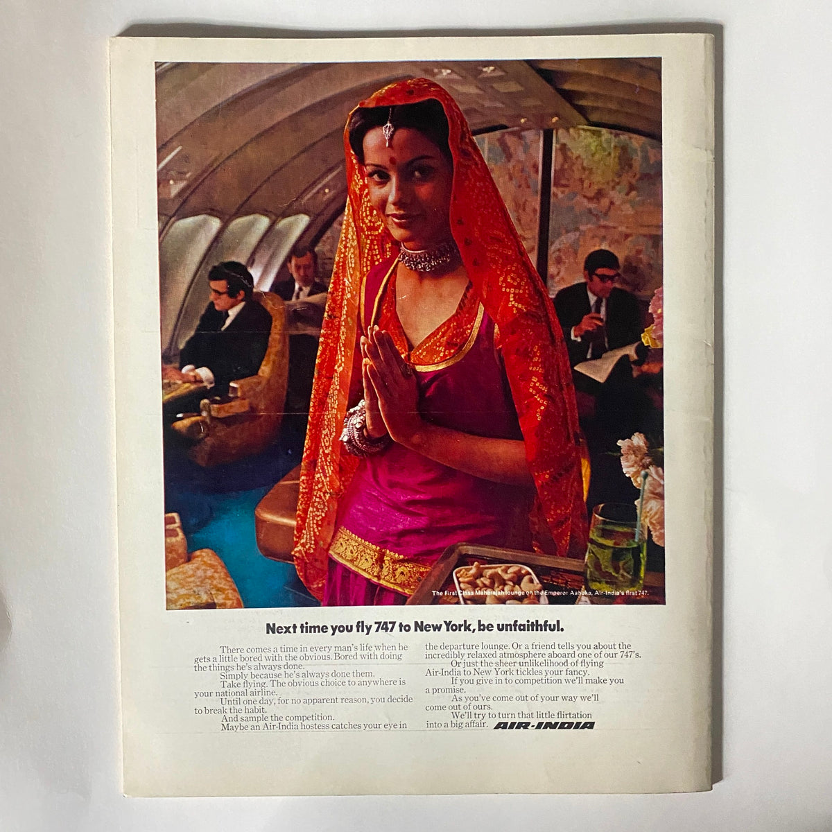 Vintage advertisement from VTG Studio International Magazine January 1972 for Air India, depicting a woman in traditional attire on a plane, promoting luxury travel to New York.