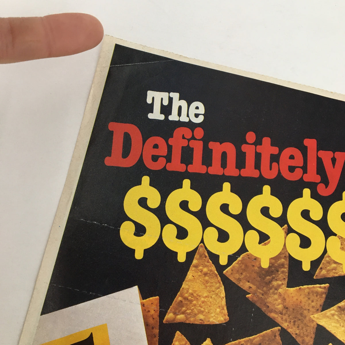 1984 Doritos Brand Tortilla Chips Circular Coupon Advertisement showing the text 'The Definitely' with dollar signs and tortilla chips, good condition, showing a few creases.