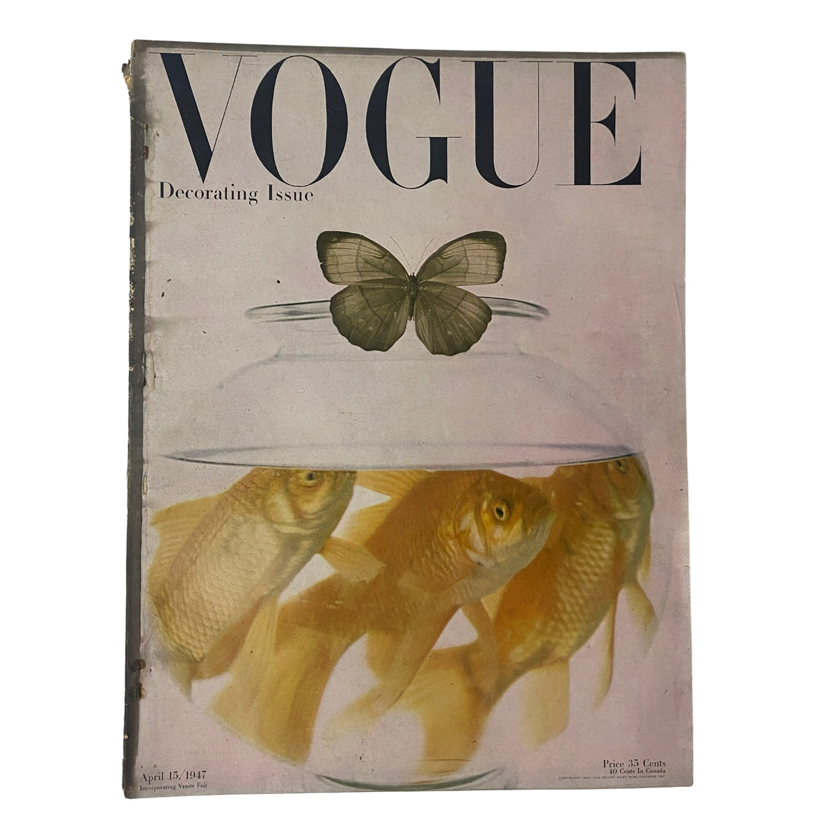 Cover of Vogue Magazine, April 15, 1947, featuring the Decorating Issue. The cover showcases a unique design with goldfish in a glass bowl and a butterfly above, emphasizing the elegance and creativity of mid-20th century design.