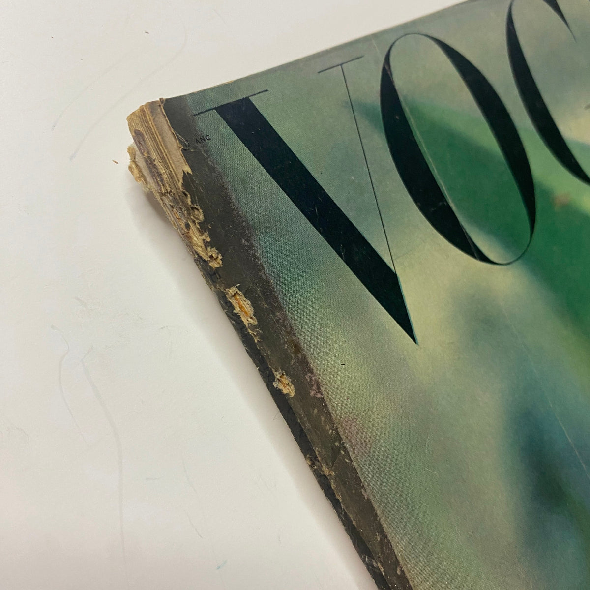 Close-up view of the edge of the Vogue Magazine cover from July 1, 1947, revealing some wear and tear, indicating its vintage nature while featuring Joan Pedersen's captivating summer-themed photograph.