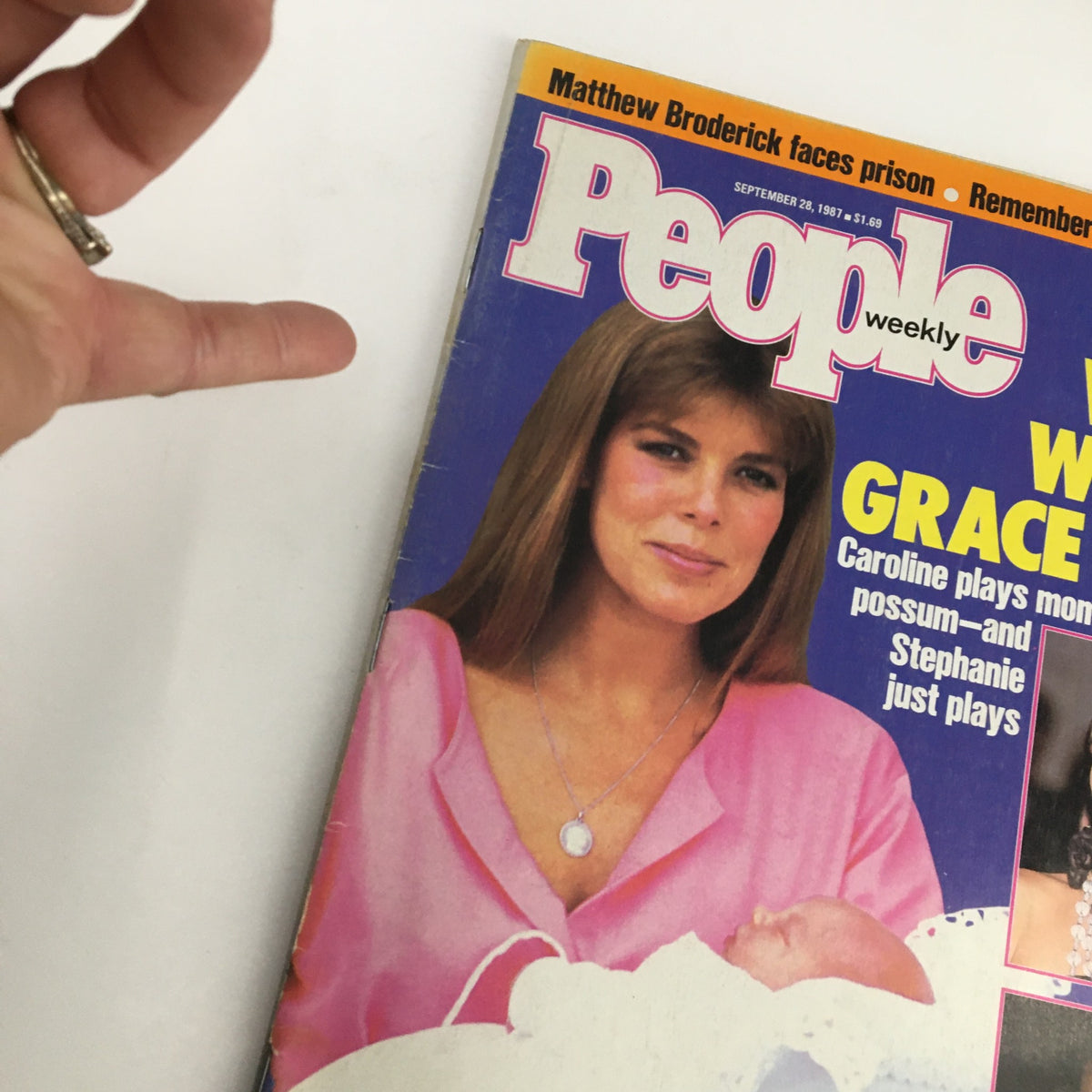 Close-up view of the cover of People Weekly Magazine from September 28, 1987, showcasing Caroline with a baby, and highlighting the title, 'What Would Grace Say?' with surrounding context of the featured personalities.