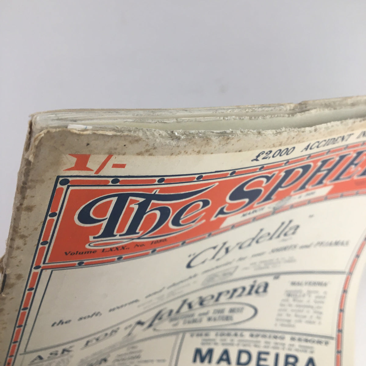 Close-up view of the top edge of The Sphere Newspaper March 6 1920, highlighting the vintage design and wear, indicative of its historical significance.