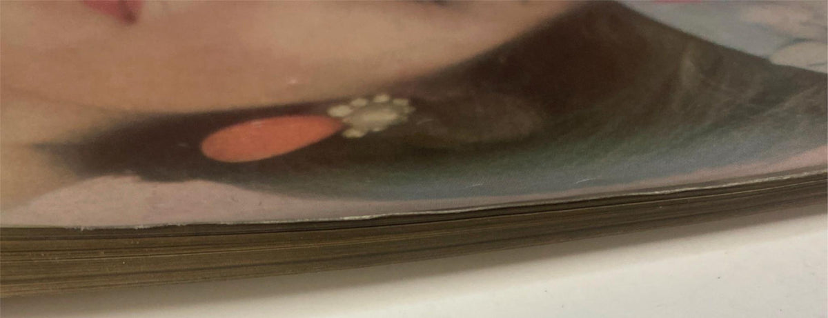 Side view of Vogue Magazine February 15, 1961 showing the worn edges of the pages, emphasizing its vintage charm and history, perfect for collectors.
