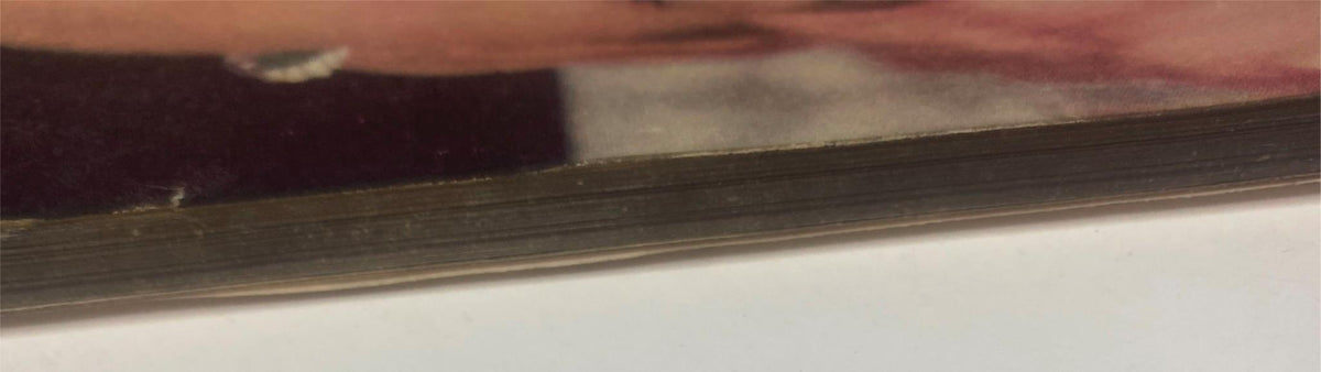 Detailed view of the binding of Vogue Magazine November 15, 1955 with Anne St. Marie cover by Henry Clarke, highlighting weathered pages and staple-rust halos.