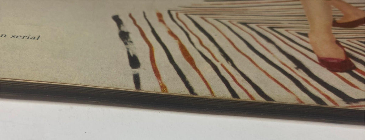 Close-up view of page edges from Vogue Magazine August 15, 1955, illustrating vintage wear such as toning on the paper, typical of mid-century magazine condition.