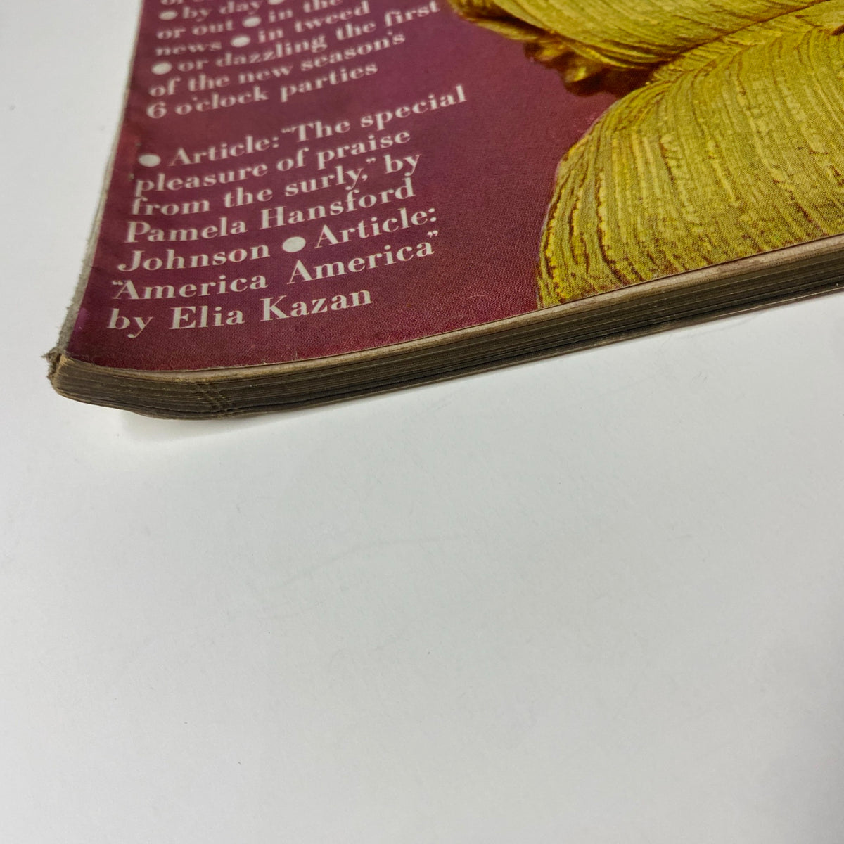 Close-up of the spine of Vogue Magazine August 15, 1957, showing the vintage magazine's wear and rich history with detailed article titles visible.