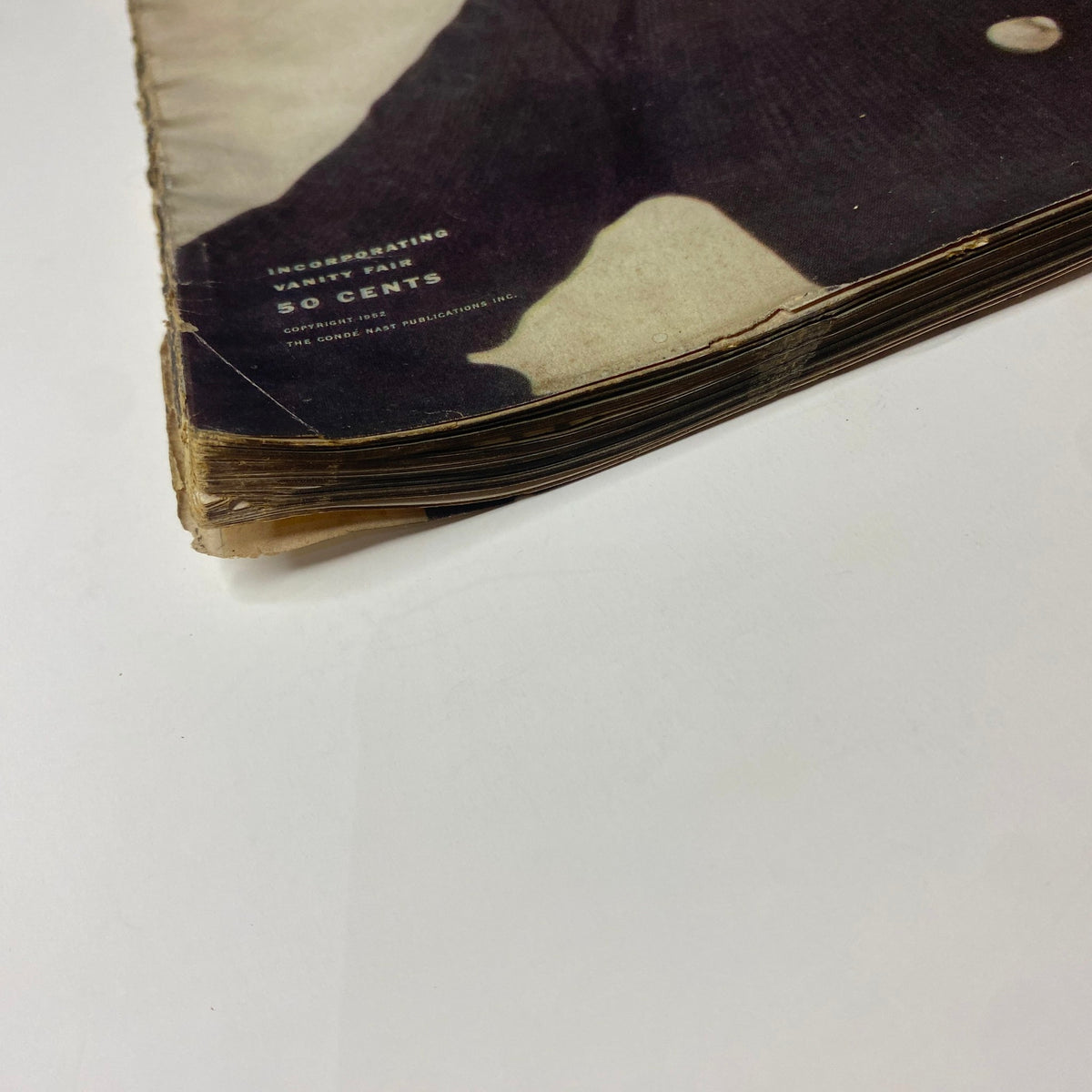 Close-up of the vintage magazine spine showcasing wear in Vogue Magazine August 15, 1952 issue, reflecting its classic appeal.