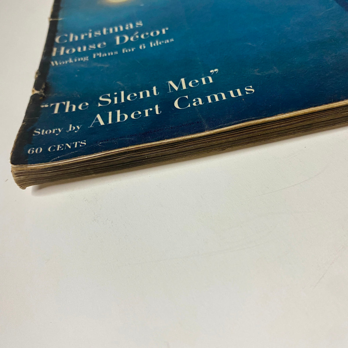 Close-up of the spine of Vogue Magazine December 1957 featuring Gyongyi Armstrong on the cover, showing vintage wear and aging typical of mid-century magazines.