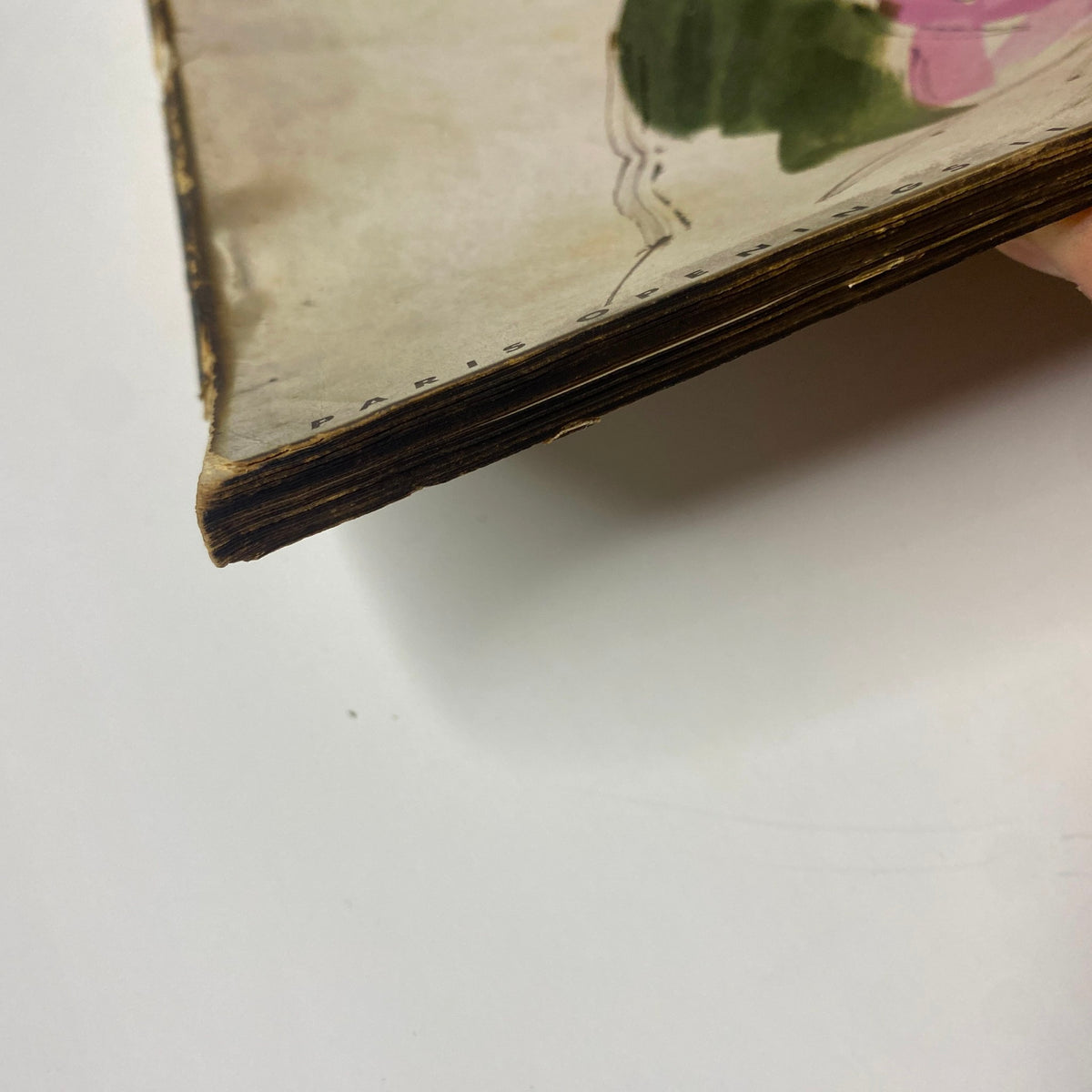 Side view of a vintage Vogue Magazine March 15, 1938, showing some wear with frayed edges, indicative of its age and history as a collectible item.
