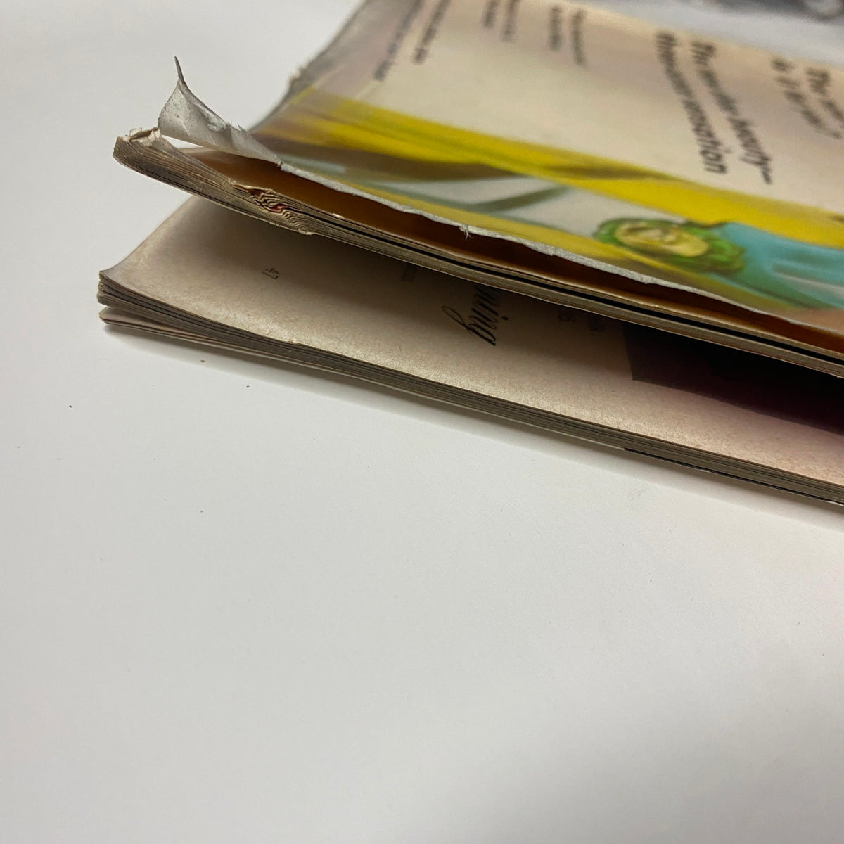 Image showing the spine of Vogue Magazine February 15, 1962, illustrating the worn condition of the pages and cover. Captures the vintage essence of the publication.