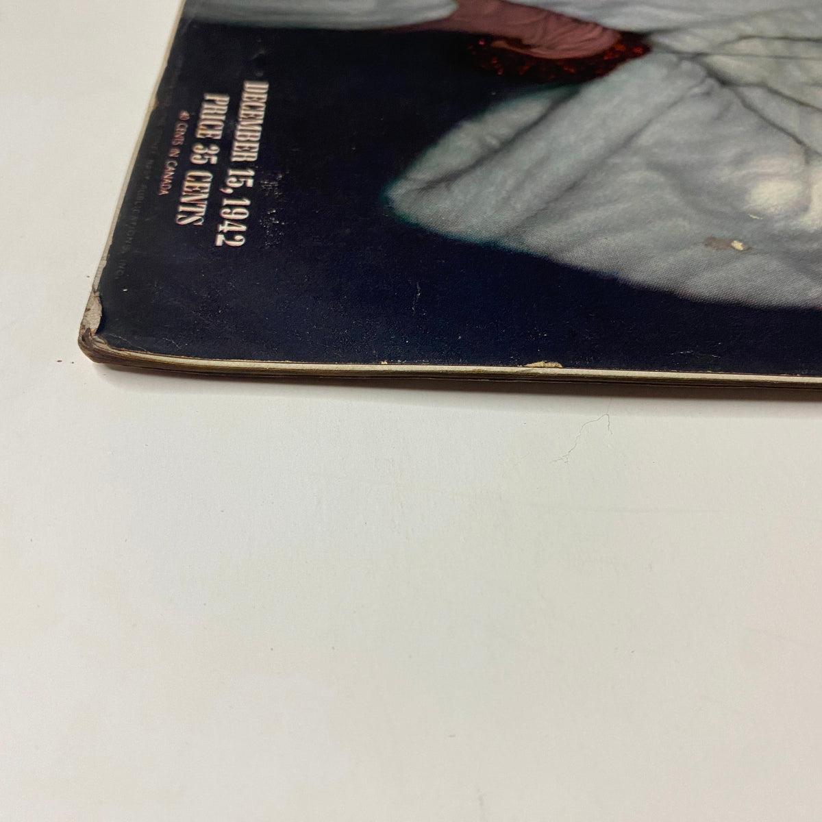 Close-up view of the spine of Vogue Magazine, December 15, 1942, showcasing slight wear and aging indicative of vintage publications. Part of the collection 'New Light On Old Questions' featuring historical content.