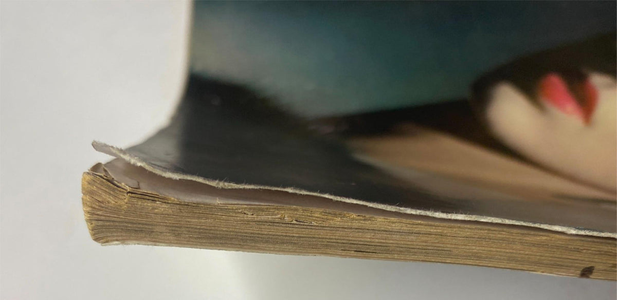 Close-up view of the spine of Vogue Magazine November 1, 1961 Sondra Peterson Cover by Horst P. Horst, showcasing edge wear and yellowed pages typical of vintage magazines.