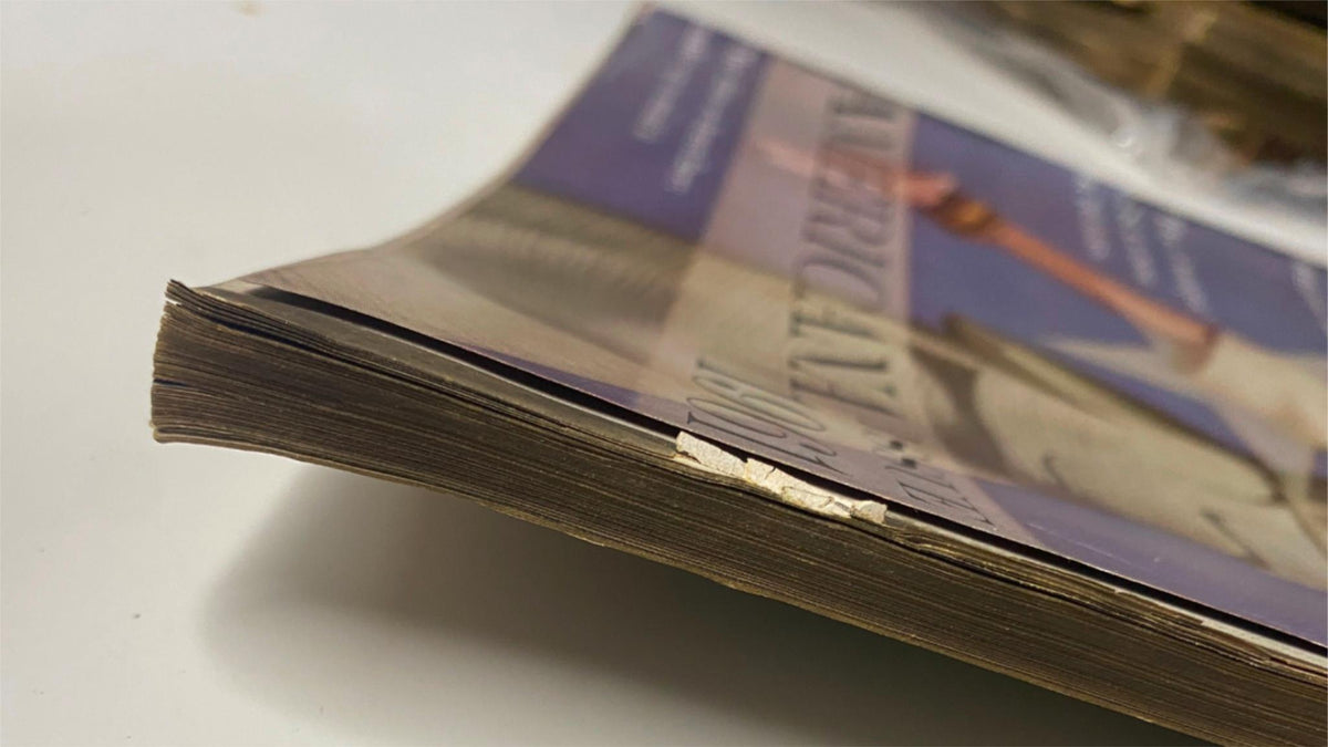 Side view of the spine of Vogue Magazine February 1, 1961, showcasing its vintage condition and wear, important for collectors of historic publications.