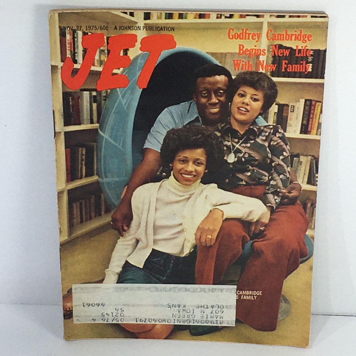 Cover of Jet Magazine, November 27, 1975, featuring Godfrey Cambridge with his family. This vintage magazine includes the title 'Godfrey Cambridge Begins New Life With New Family'. The image showcases a joyful family portrait with Cambridge and two women, set against a backdrop of bookshelves.