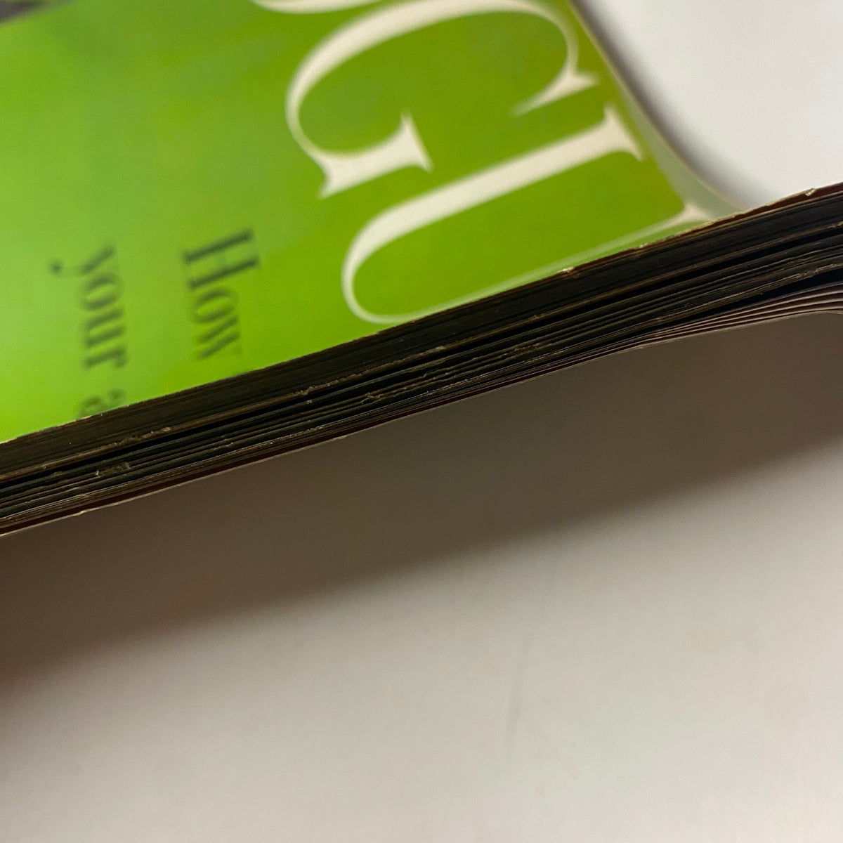 Detailed view of the pages' edge of Vogue Magazine from April 15, 1957, titled 'How To Keep Your Audience' by Richard Rutledge, highlighting the magazine's age with visible yellowing.