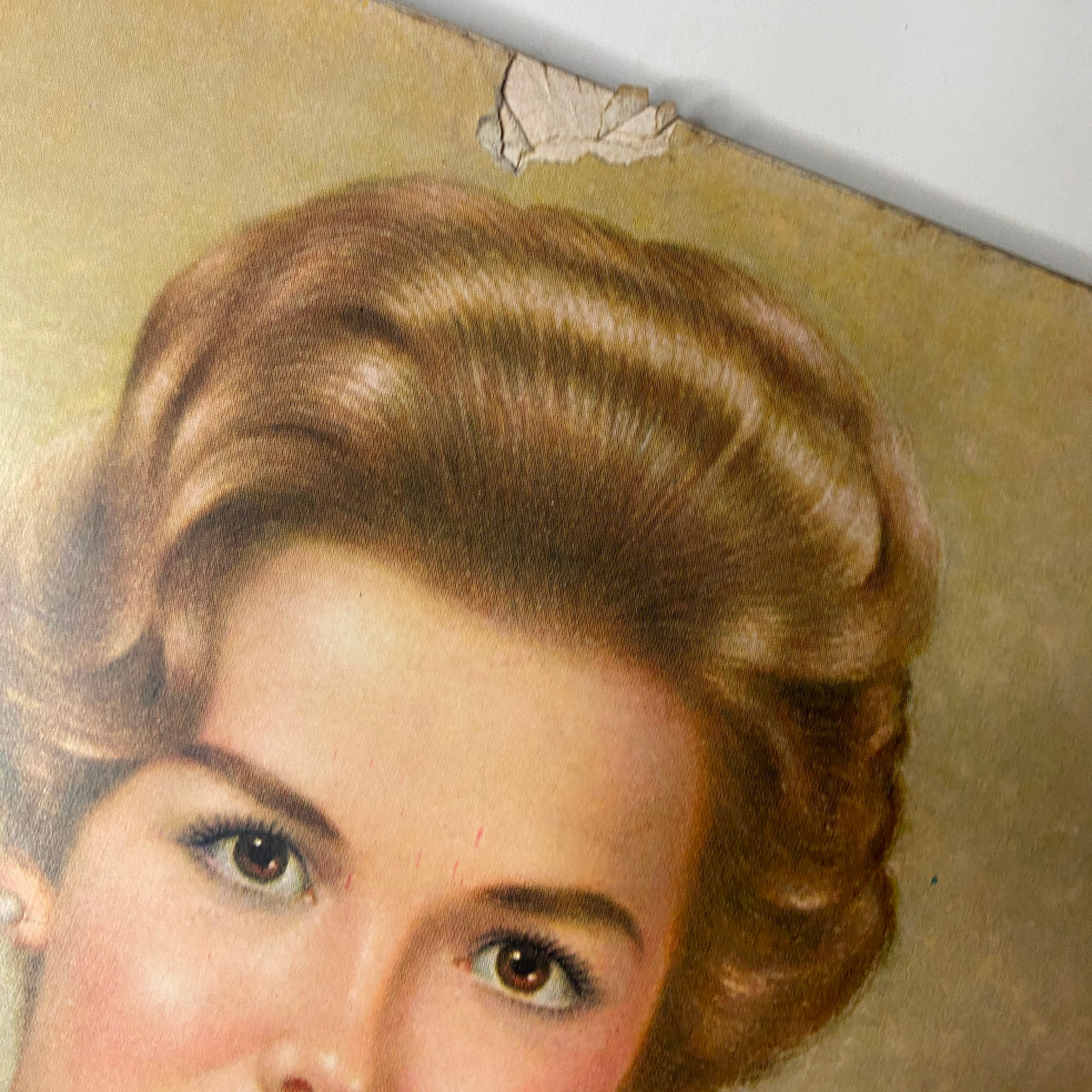 Close-up of the damage on the cover of Vogue Magazine March 15, 1962, showing a corner tear, illustrating the magazine's vintage condition.