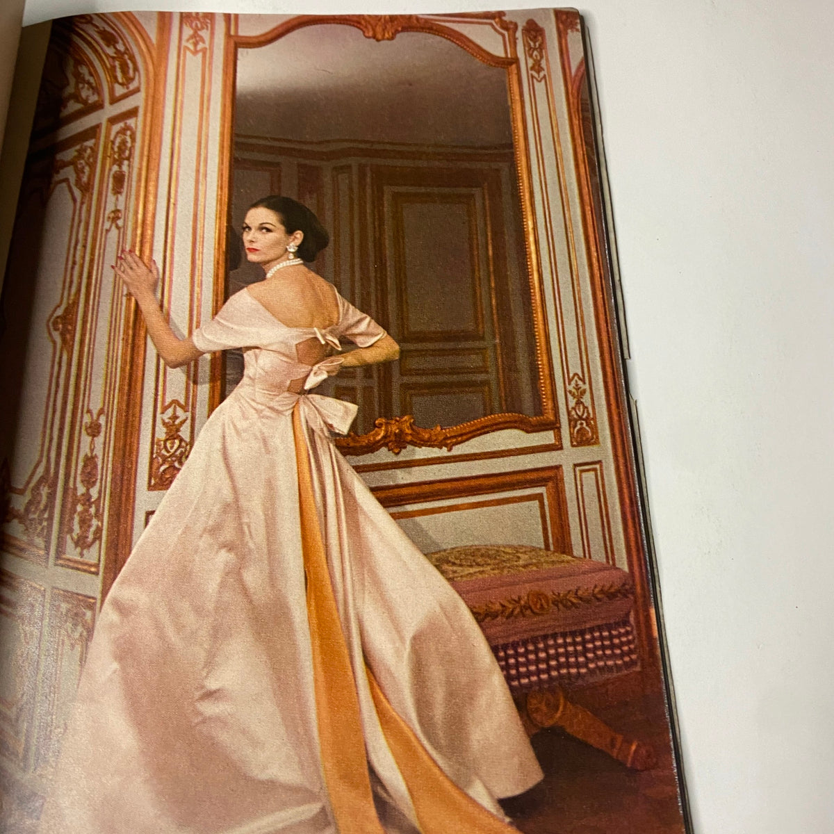 Elegantly styled model in a flowing gown featured in Vogue Magazine November 1, 1955 Anne St. Marie cover, showcasing mid-century fashion.