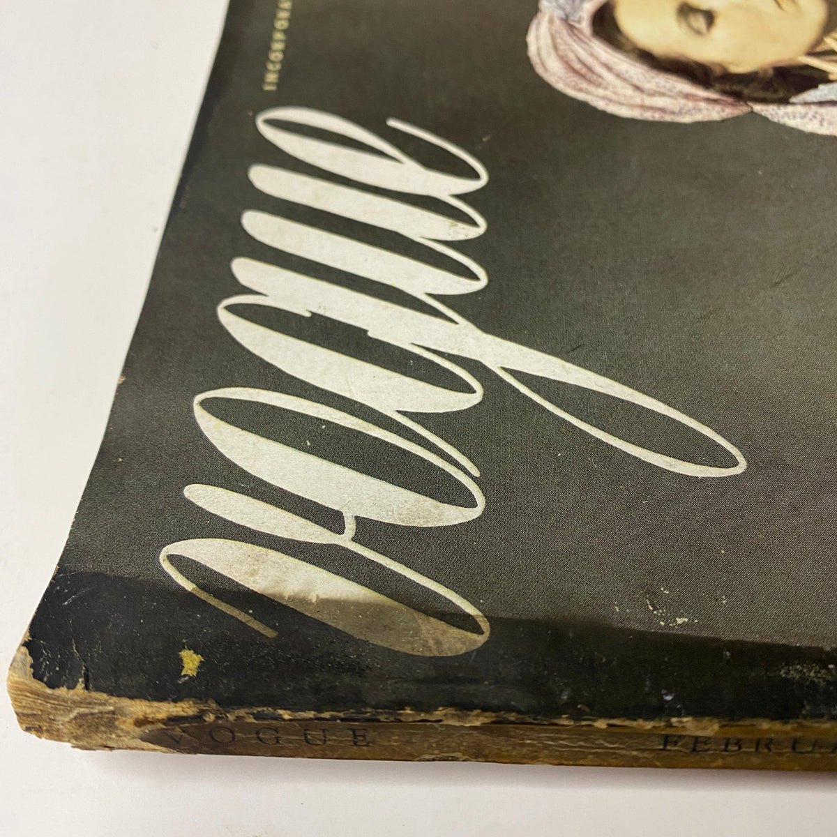 Close-up view of the worn cover of Vogue Magazine February 15, 1938 featuring Angelica Welldon by Horst P. Horst, showcasing the vintage typography and condition of the spine.