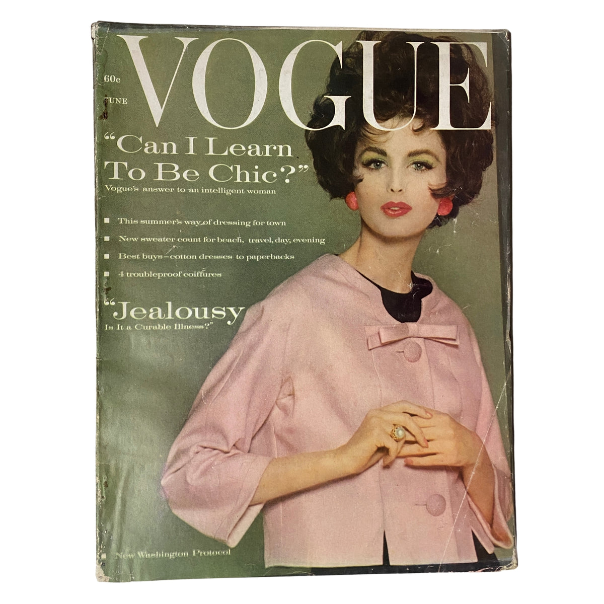 Vogue Magazine cover from June 1961 featuring Dorothy McGowan, styled in a pink jacket and statement ring, with the headline 'Can I Learn To Be Chic?' showcasing mid-century fashion.