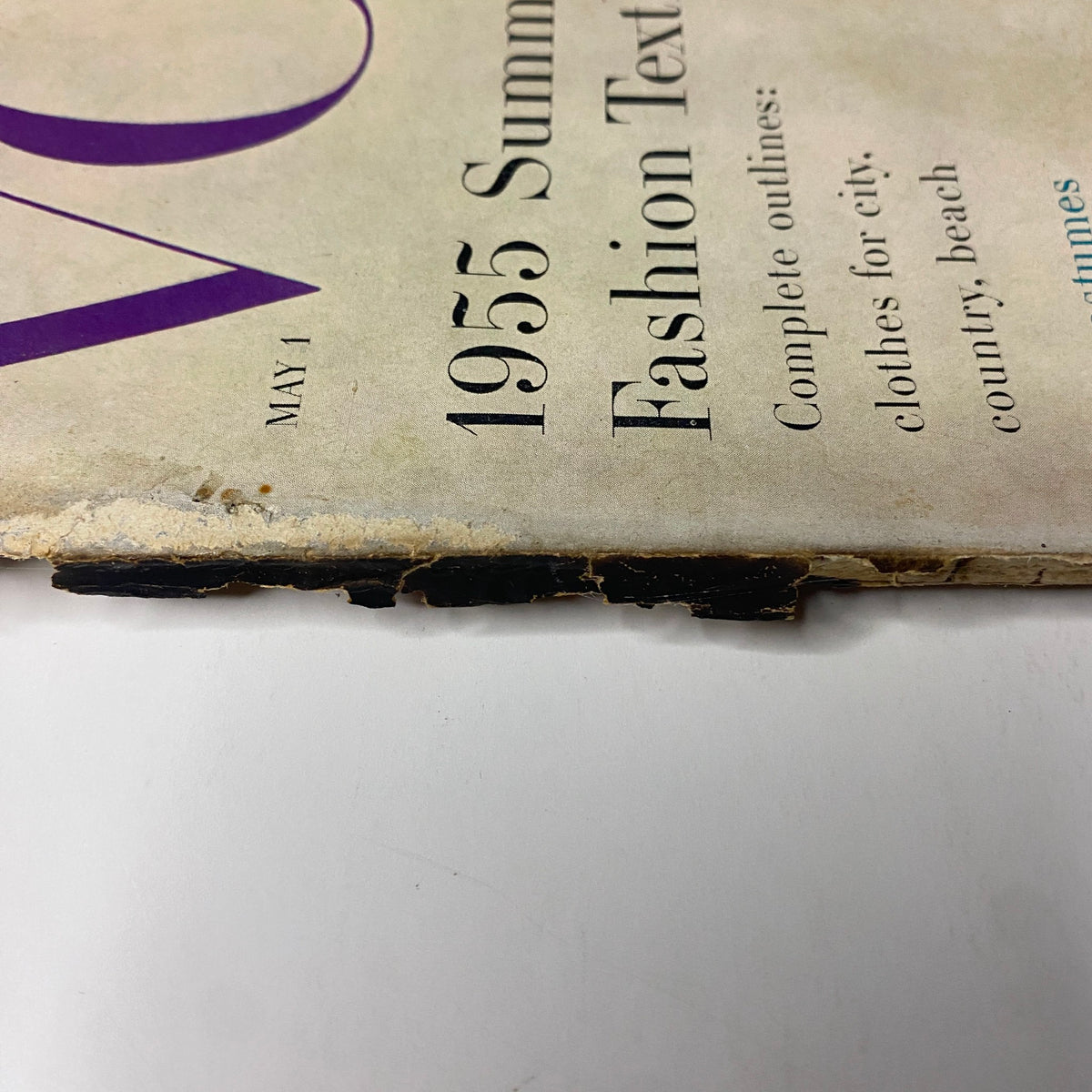 Close-up detail of the spine of Vogue Magazine May 1, 1955 Summer Fashion Textbook, showing wear consistent with age, highlighting its vintage authenticity.