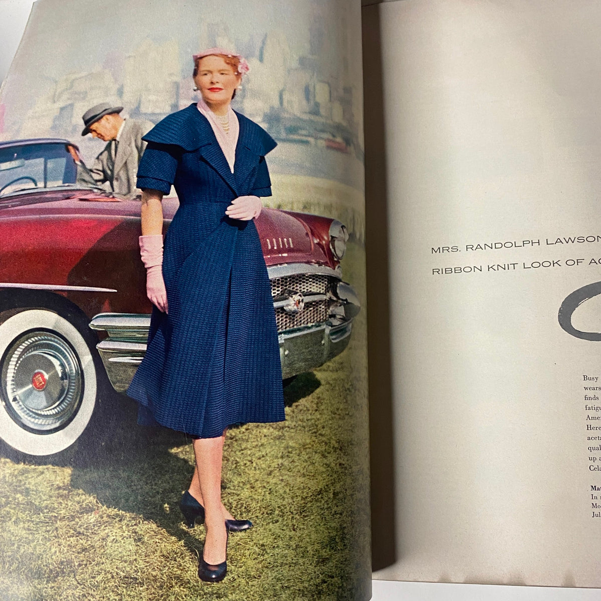 A chic model in a navy dress featured in Vogue Magazine May 1, 1955 Summer Fashion Textbook, embodies mid-century elegance.