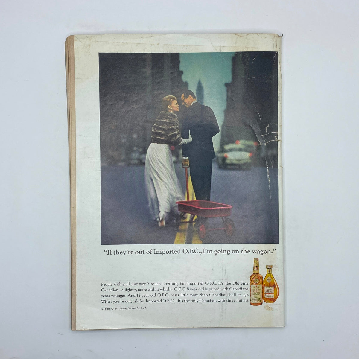 Back cover advertisement from The New Yorker magazine September 26, 1964, portraying a couple in a city setting with a tagline related to Imported O.F.C. whiskey.