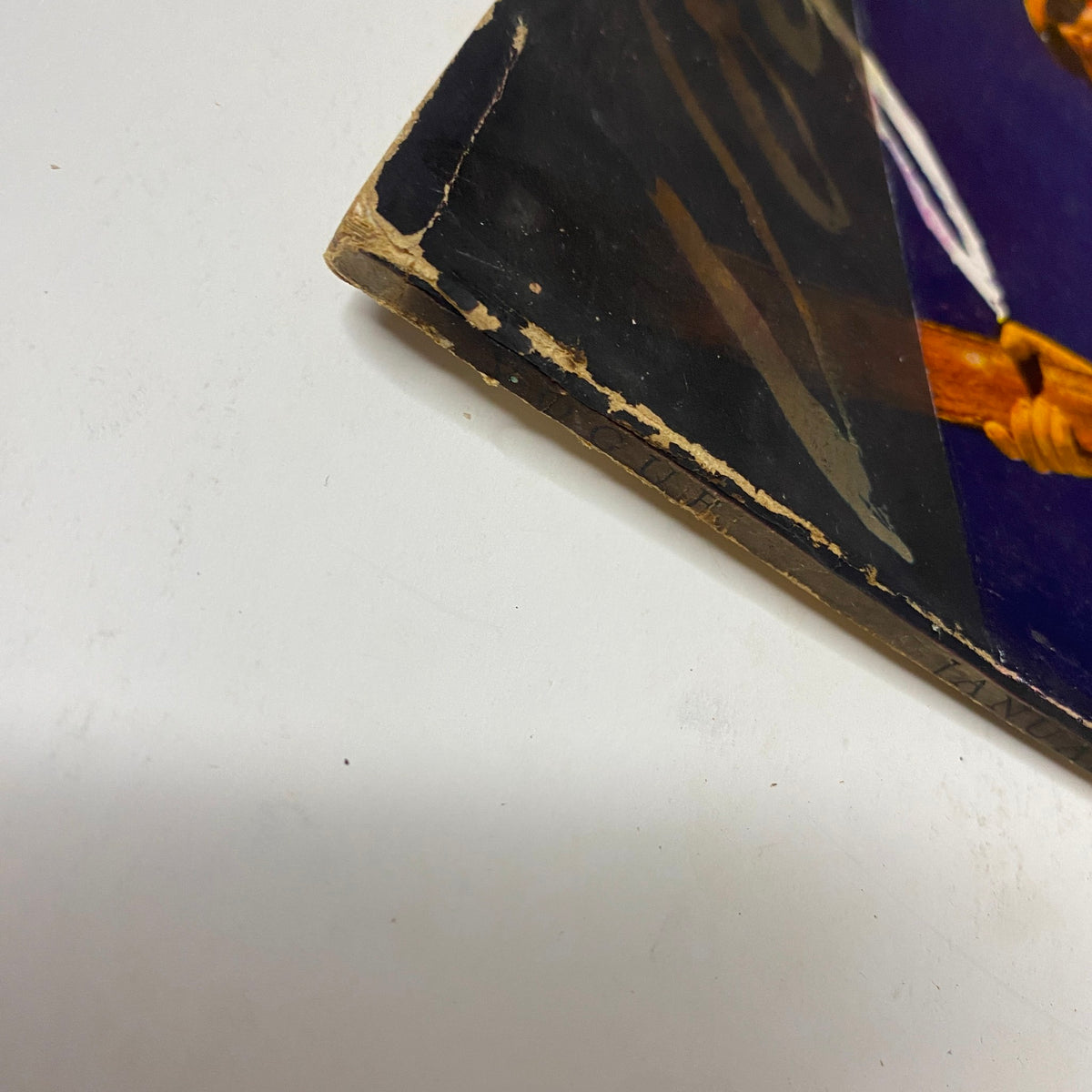 Close-up of the spine of Vogue Magazine January 1, 1941 Ski Girl Cover by Toni Frissell, showing wear and tear.