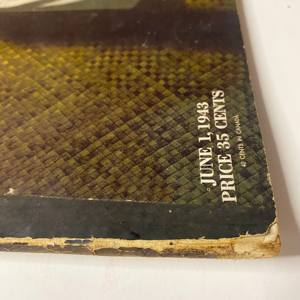 Detail view of the bottom edge of Vogue Magazine June 1, 1943, showing the publication date and price, emphasizing vintage characteristics.