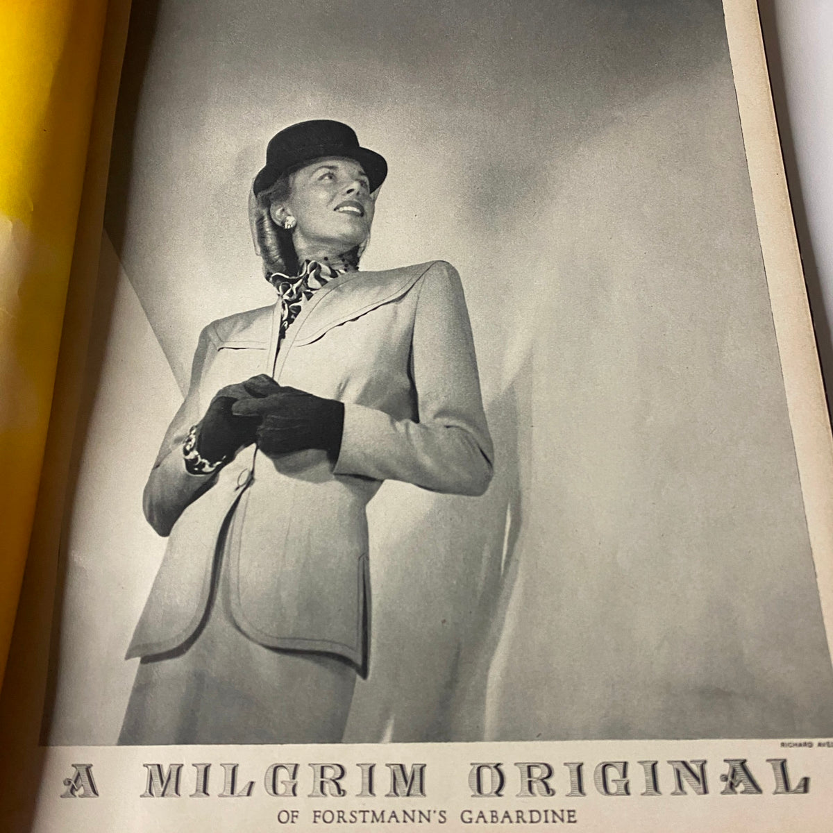 Interior page from Vogue Magazine February 15, 1945 displaying a black and white photograph of a model in a stylish suit, featuring A Milgrim Original of Forstmann's Gabardine.