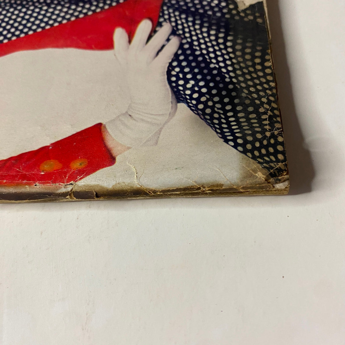 Detailed image of the lower corner of the March 15, 1955 Vogue Magazine, featuring Sunny Harnett by John Rawlings and showing signs of aging.