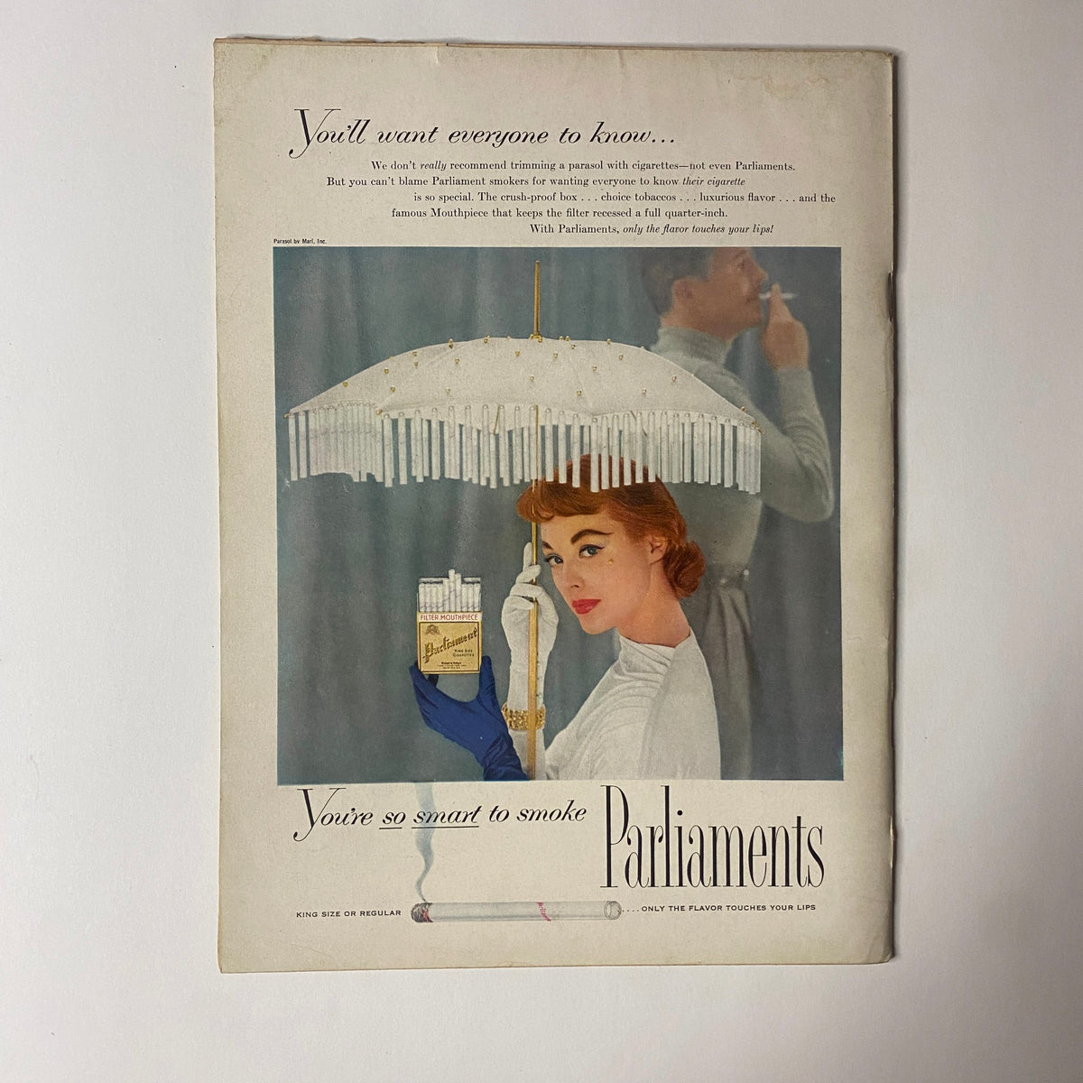 Vintage advertisement featuring a woman holding a pack of Parliaments cigarettes under a decorative umbrella, highlighting the slogan 'You're so smart to smoke Parliaments'. This image captures a mid-20th century aesthetic, relevant to the promotional style of the time.