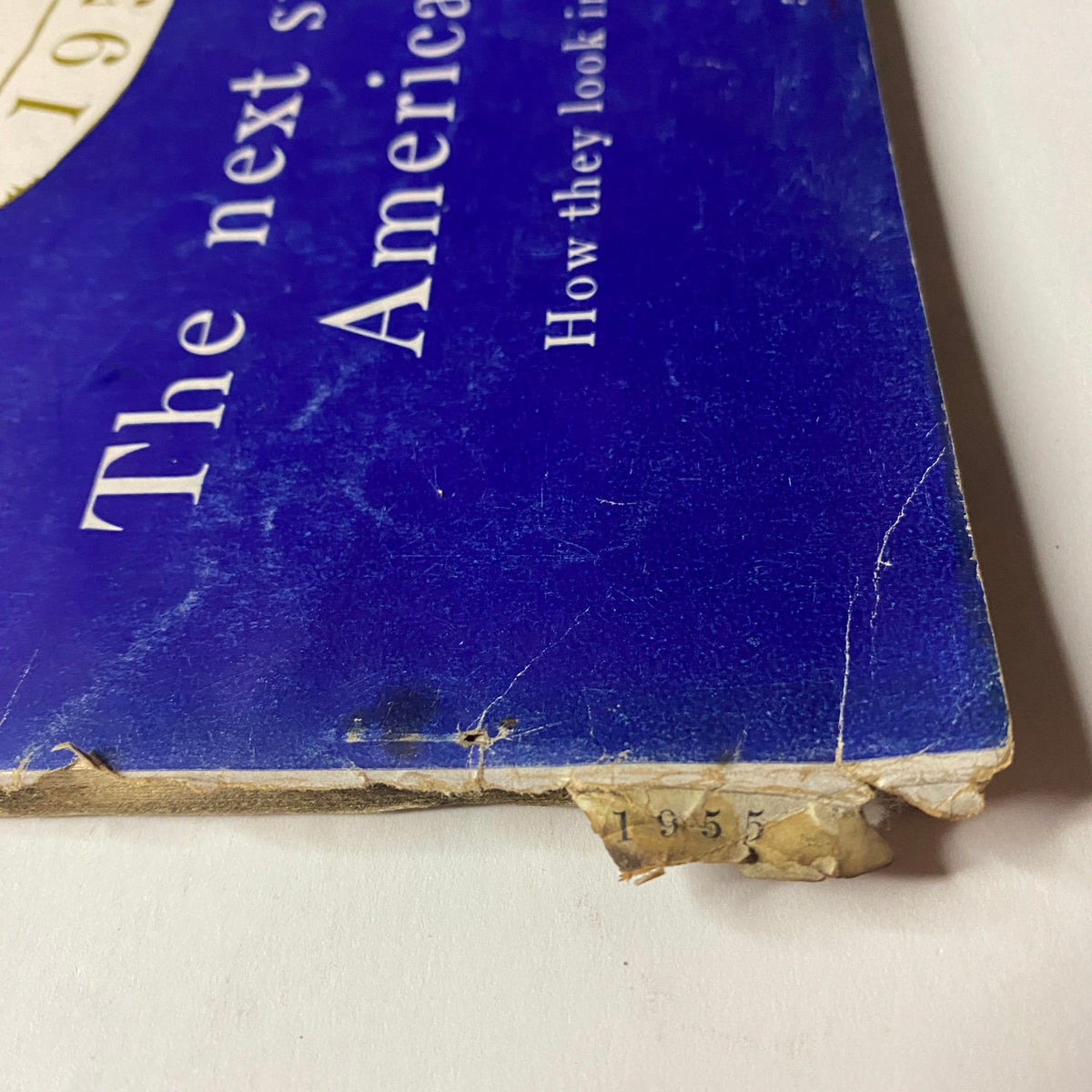 Detail of the worn corner of Vogue Magazine February 1, 1955 Americana Number 1955, showcasing age and condition with visible damage.