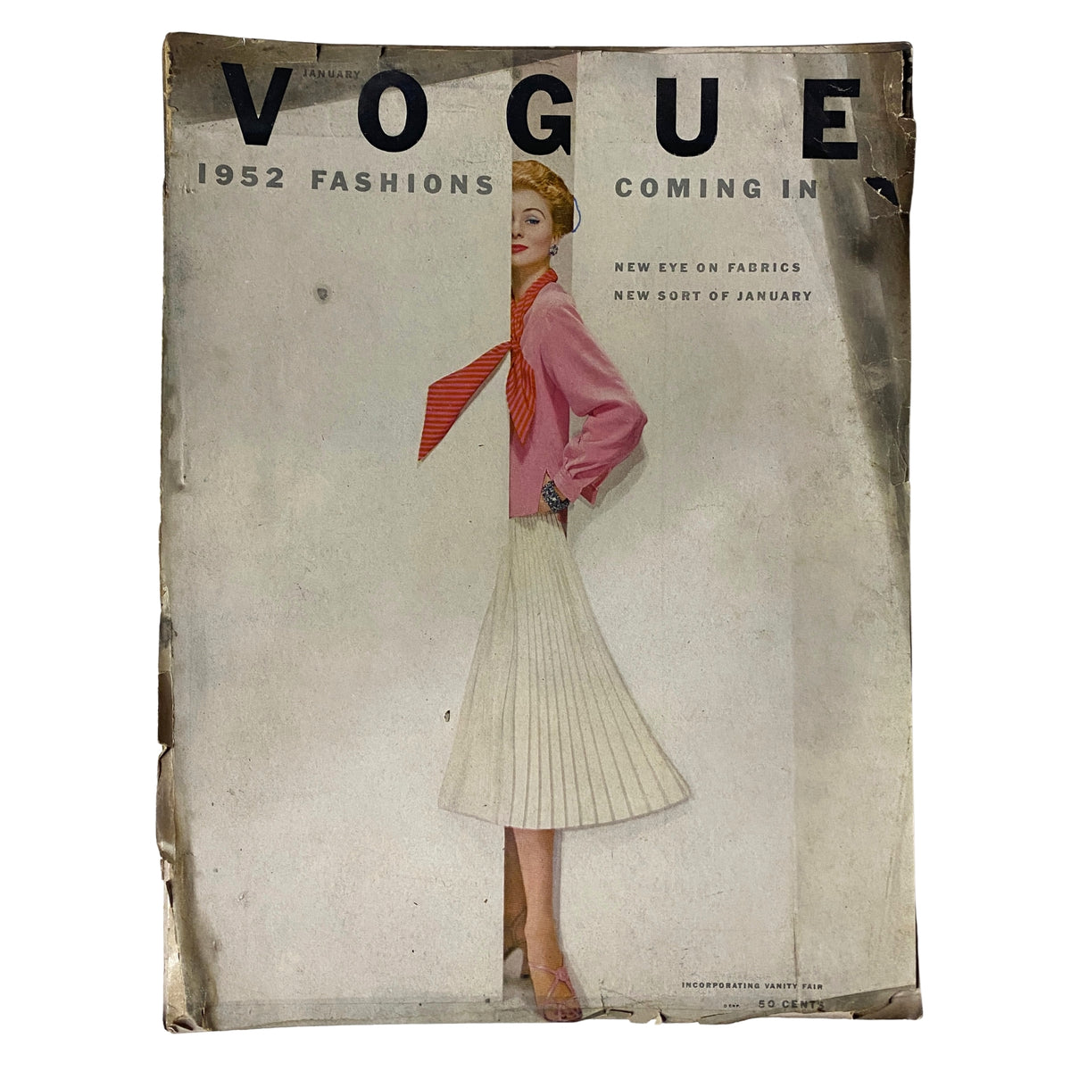 Vogue Magazine January 1952 cover featuring a model in a pink top and pleated skirt, showcasing vintage fashion styles with visible wear and tear.
