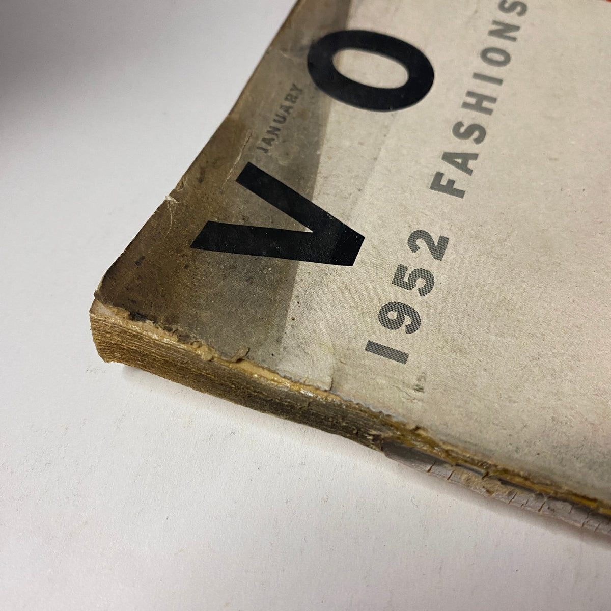 Side view of the January 1952 Vogue Magazine showing damage on the spine, with worn pages indicating its age and previous storage.