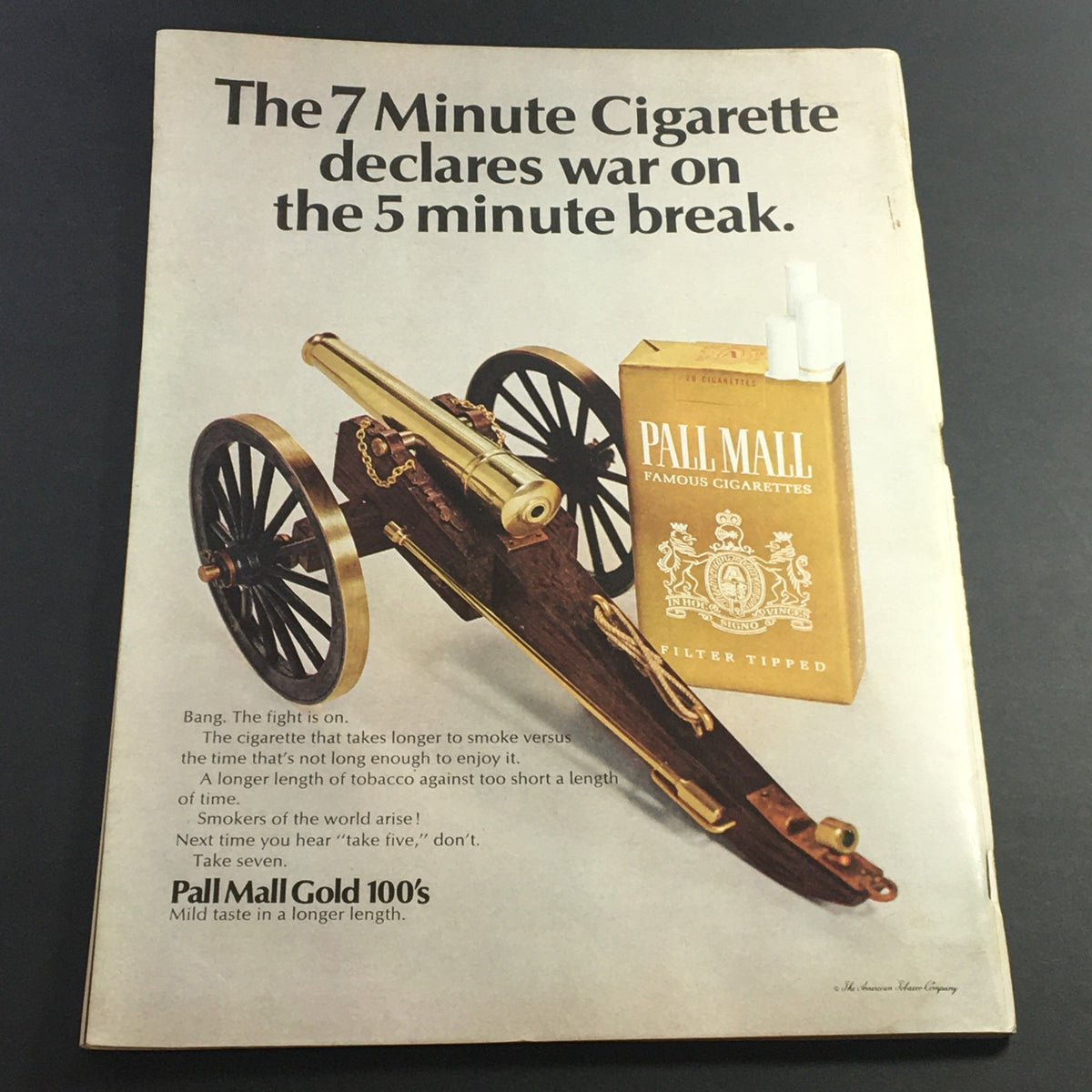 Back cover of a vintage advertisement for Pall Mall cigarettes, showcasing a cannon and stating 'The 7 Minute Cigarette declares war on the 5 minute break.'