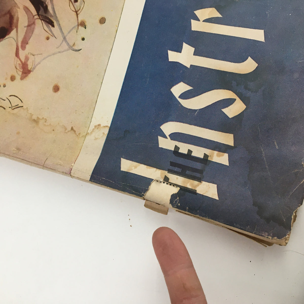 Close-up of wear on the cover of The Instructor Magazine November 1958 featuring The Horseman by Eugene Delacroix, highlighting visible damage and finger pointing to the issue.