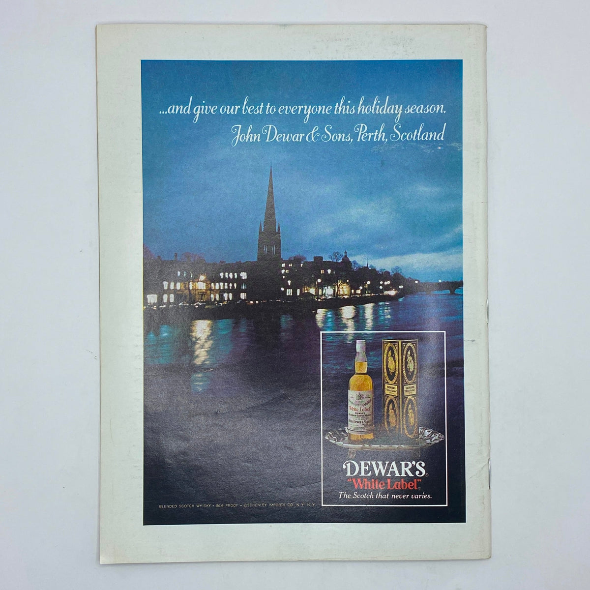 Vintage advertisement for Dewar's White Label Scotch on the back cover of The New Yorker Complete Magazine December 27, 1976, featuring a scenic view of a riverside town at dusk.