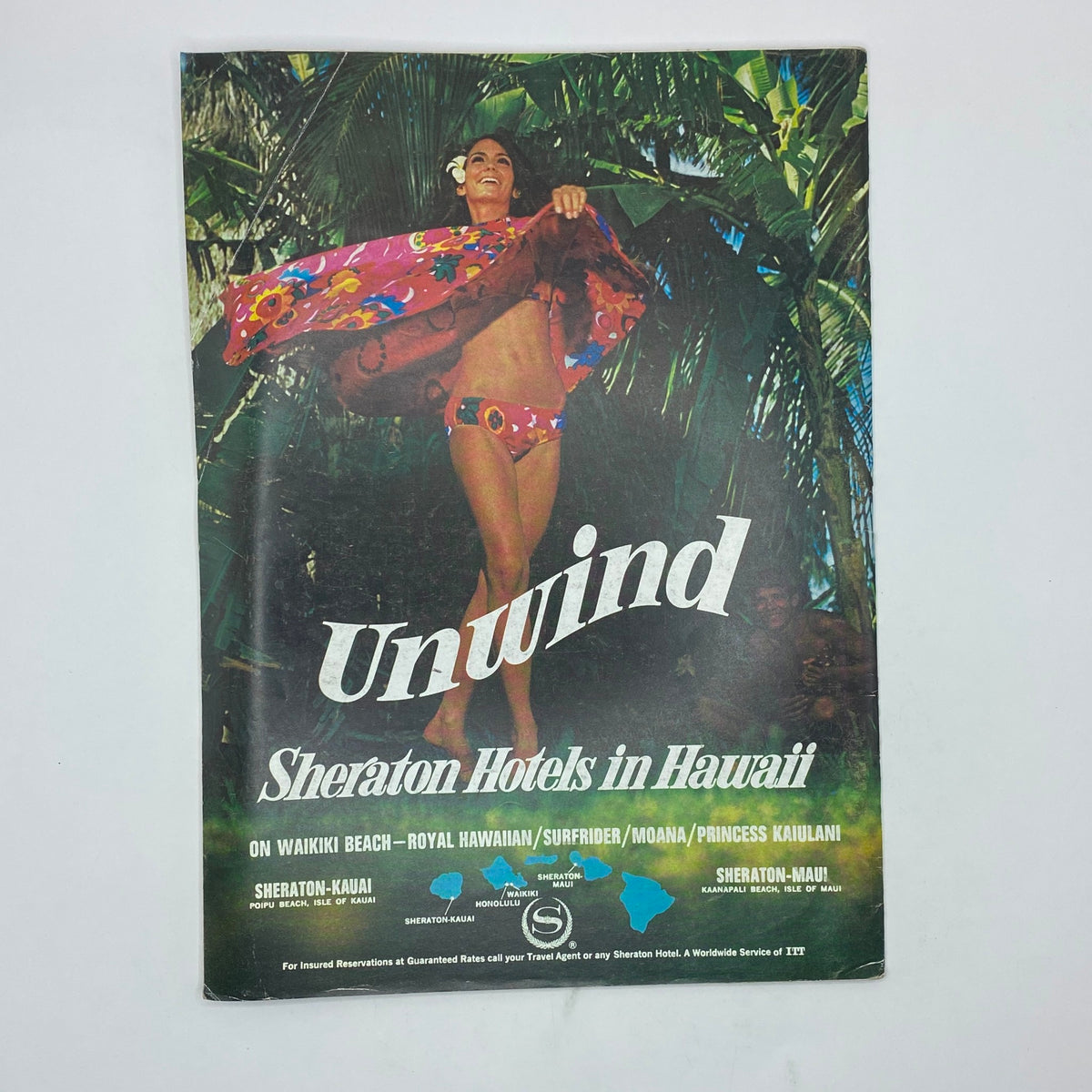 Vintage promotional magazine cover for Sheraton Hotels in Hawaii, featuring a woman in a floral swimsuit and wrap, with text 'Unwind' creatively displayed.