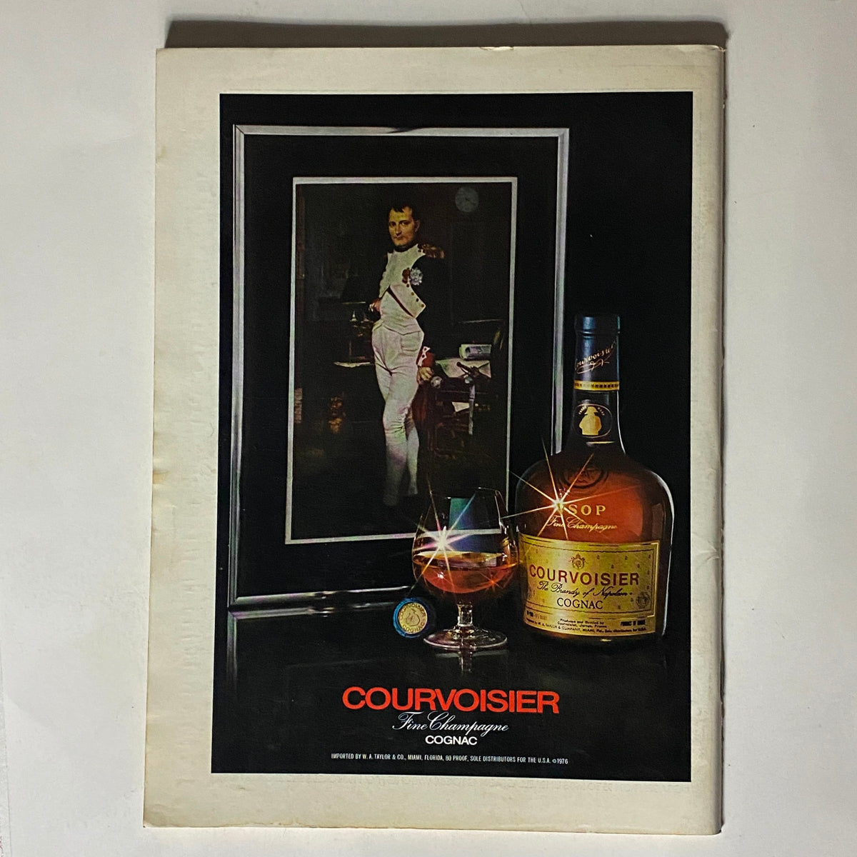 Vintage advertisement for Courvoisier Fine Champagne Cognac featured in The New Yorker Complete Magazine September 27, 1976, illustrating a bottle of cognac, a glass, and an elegant portrait.