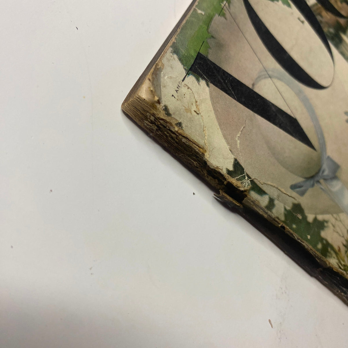 Side view of the vintage Vogue Magazine cover from April 1, 1948, revealing wear and tear at the edges, featuring a Summer Fashion Preview with a woman in a fashionable outfit amidst a garden setting.