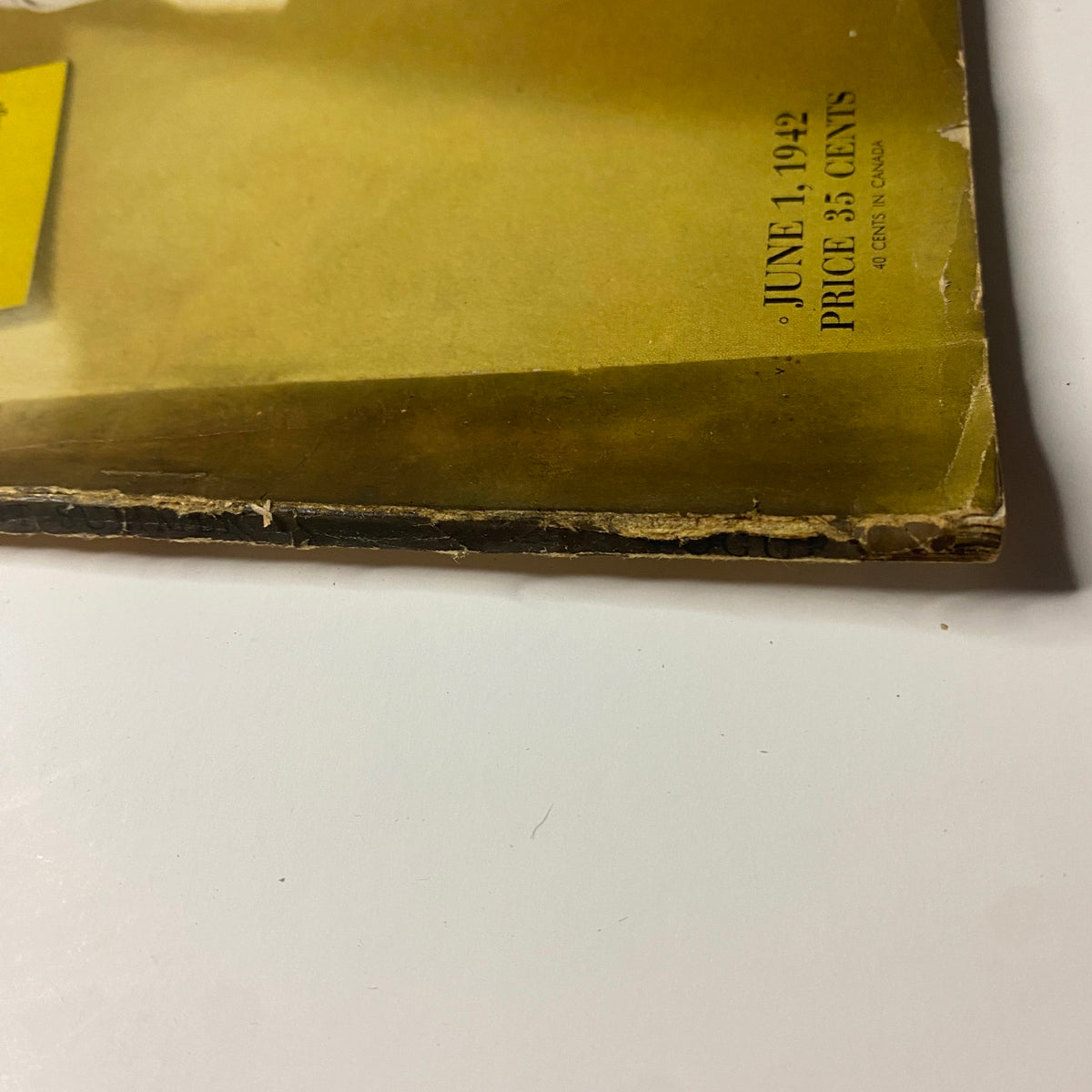 Close-up of the corner of Vogue Magazine June 1, 1942, indicating vintage wear and creases. The cover features Betty McLauchlen and summer fashion themes.